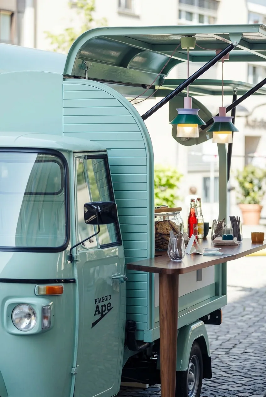 Türkise Pocissimo Coffee Ape mit Theke und Lampen im urbanen Werkhallen-Setting
