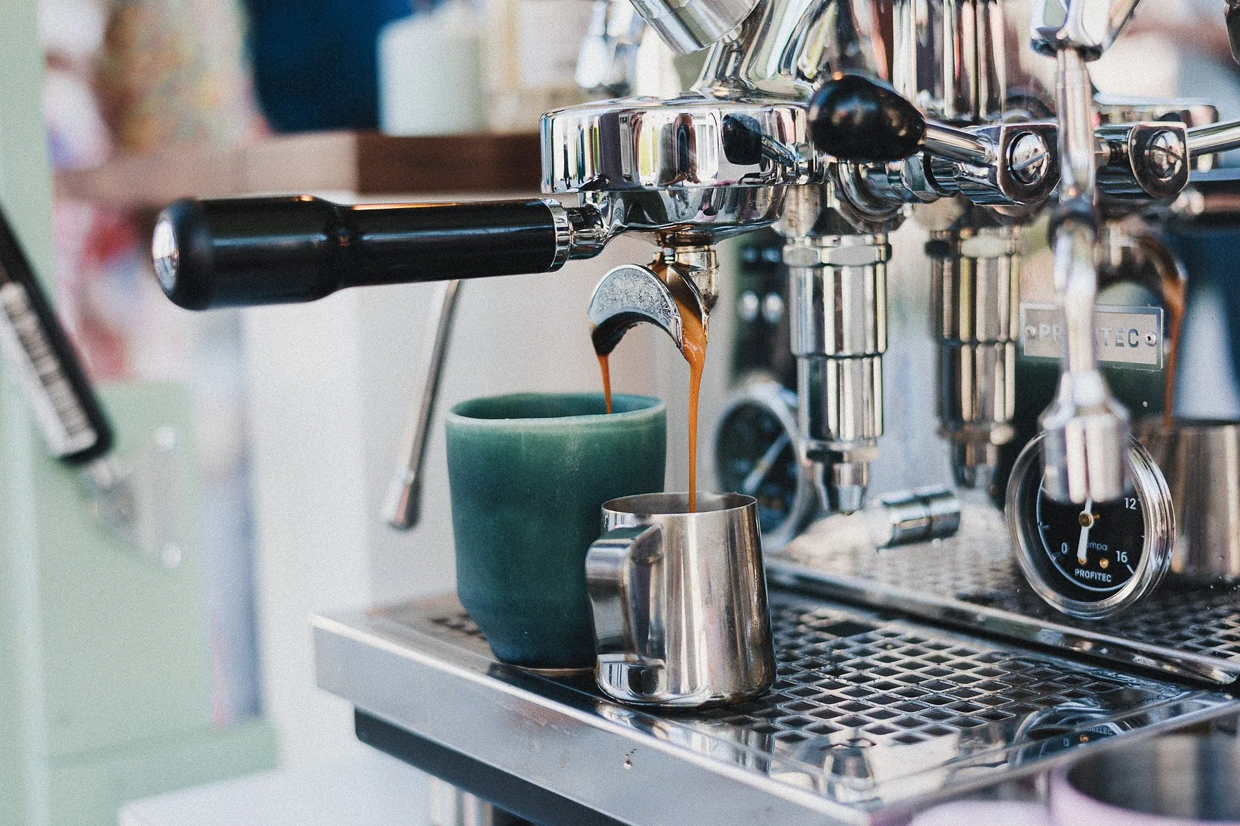 Espresso fließt in grüne Keramik-Tasse